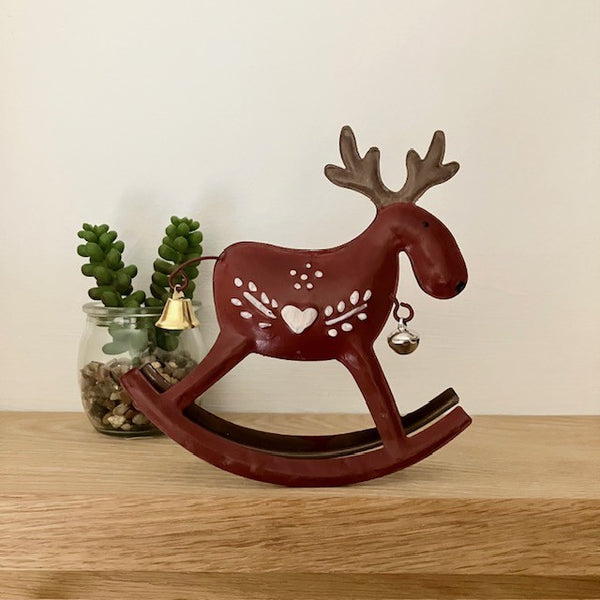 Side view of dark red metal reindeer that rocks with pretty Scandinavian paintwork design and bells