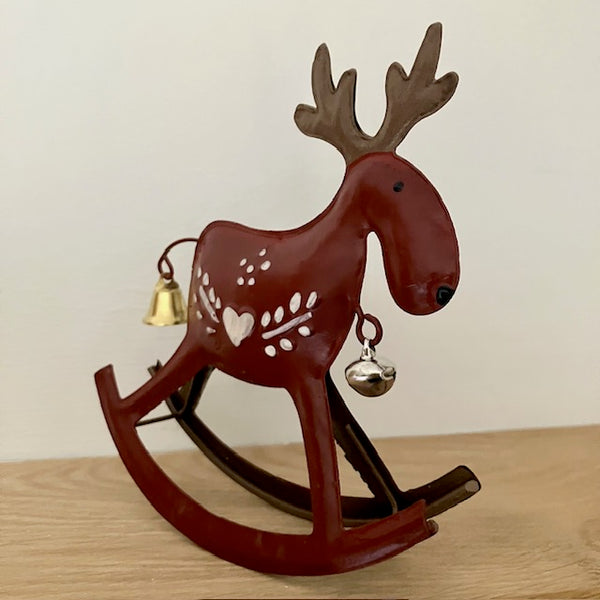Front view of dark red metal reindeer that rocks with 
pretty Scandinavian paintwork design and bells