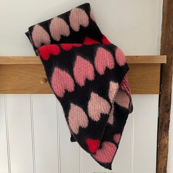 The Amora Scarf Black and Red is a gorgeous hug of a scarf with it's big statement love heart pattern and lots of super soft, cosy material to wrap you up in