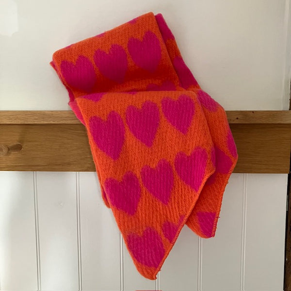 The Amora Scarf Orange and Pink is a gorgeous hug of a scarf with it's big statement love heart pattern and lots of super soft, cosy material to wrap you up in 
