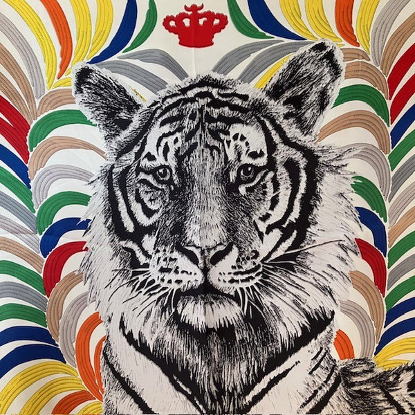 The Babar Scarf has a stunning tiger's face in black and white surrounded by coloured feathers and has a red crown.