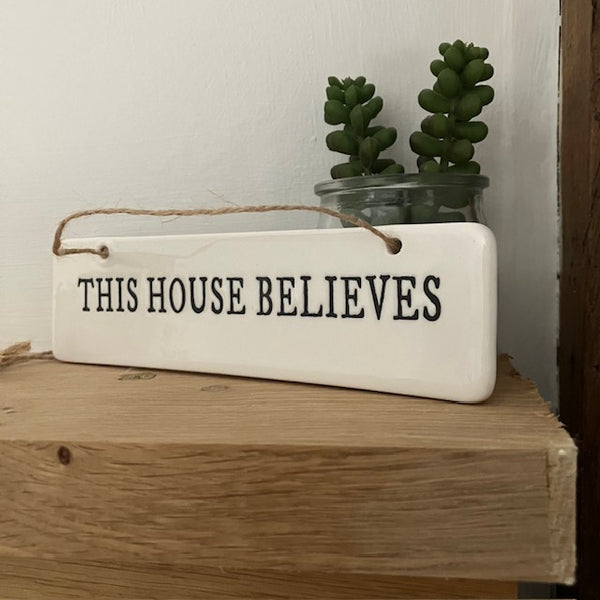 The This House Believes Sign is a super cute little ceramic hanging decoration