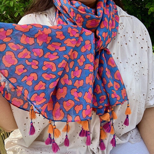 The Cari Scarf Blue has alternating pink and orange tassels at the end of this rectangular scarf
