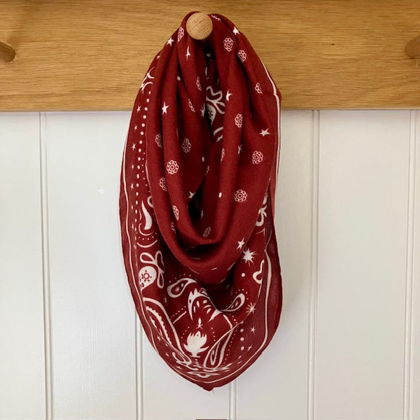 The Dolly Scarf Burgundy features a fabulous western style pattern of stars, dots, paisley and small flowers giving it that lovely cowgirl look that's so on trend at the moment