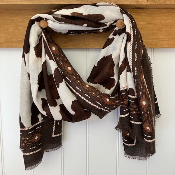 The Ella Scarf Brown features a gorgeous cow hide style print with a striking Aztec-inspired border