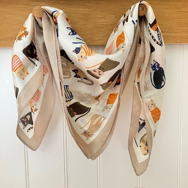 The Faeleen Scarf Champagne is a small square with a fabulously fun stylish cats repeating pattern. Ideal for styling into the on-trend small neck and triangle tied scarves.