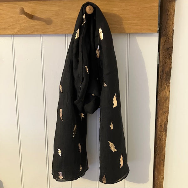 The Levina Scarf is black with rose gold lightening bolt pattern