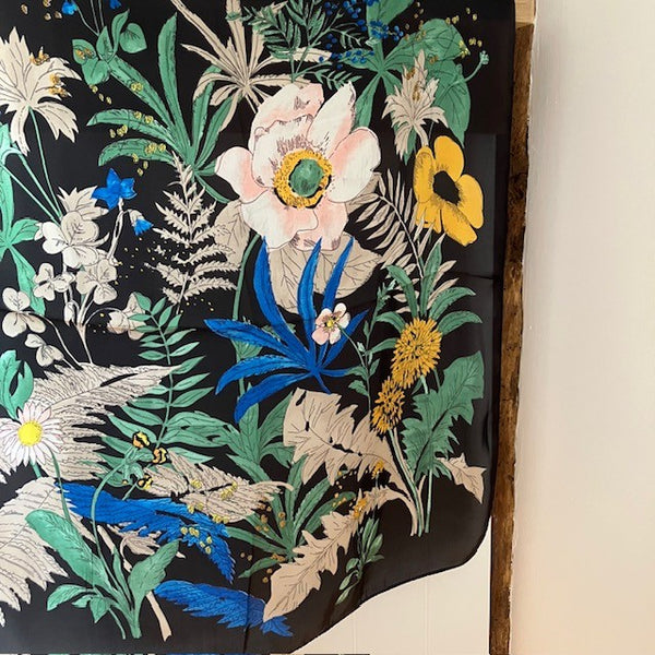 The Meadow Scarf Black is a square scarf with a bold floral pattern