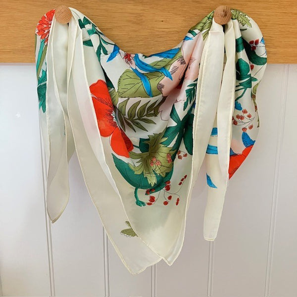 The Meadow Scarf Cream is a small square with the most beautiful bold flower design. Ideal for styling into the on-trend small neck and triangle tied scarves.