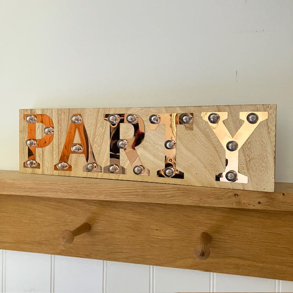The Copper and Wood 'PARTY' Light Up Sign is the perfect home decor for party goers and people who love to entertain