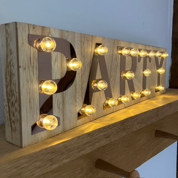 The Copper and Wood 'PARTY' Light Up Sign can either be free standing or has hanging brackets on the back to easily put up on a wall