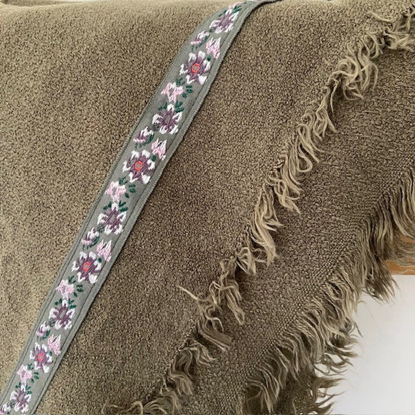 The Samantha Scarf Khaki has a pretty embroidered ribbon with flowers on, around the side edges
