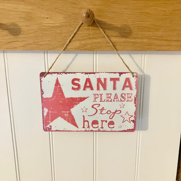 Decorative Christmas sign with red stars and text 'Santa Please Stop here' hanging on a rope