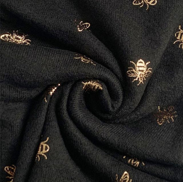 The Abella Snood Gold Bee Black is a wonderfully cosy and shimmering eye catching bee print snood