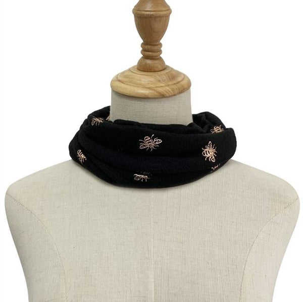 The Abella Snood Gold Bee Black is a wonderfully cosy and shimmering eye catching bee print snood