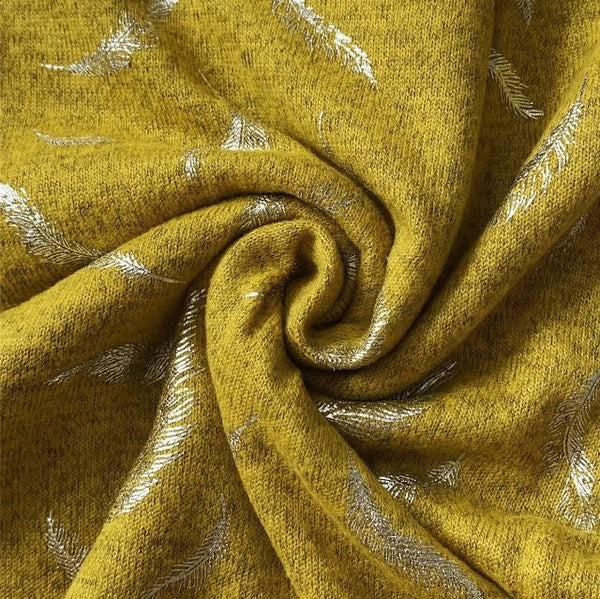 The Abella Snood Silver Feather Mustard is a wonderfully cosy and shimmering eye catching snood